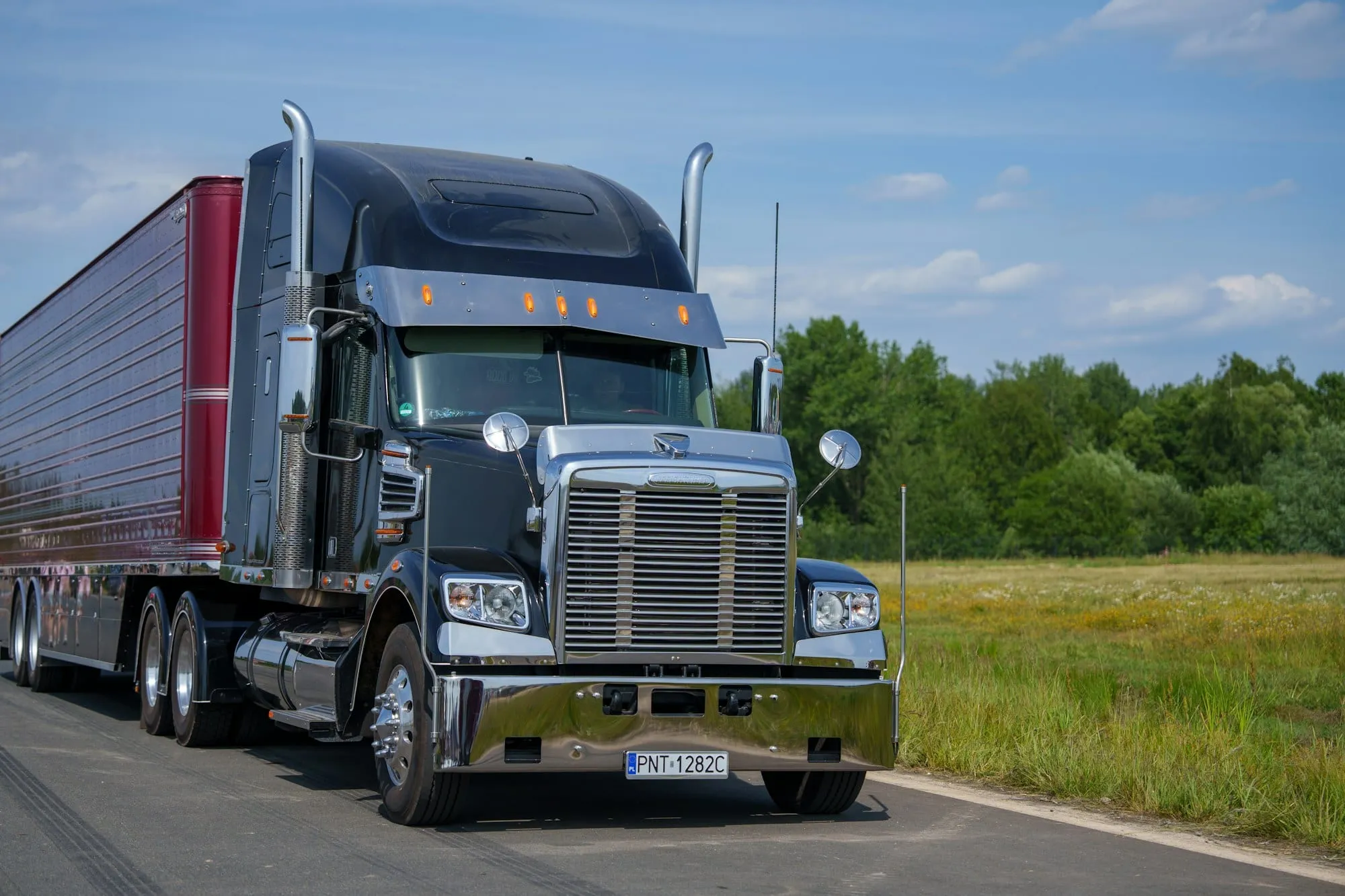 Black semi truck with a refrigerated trailer