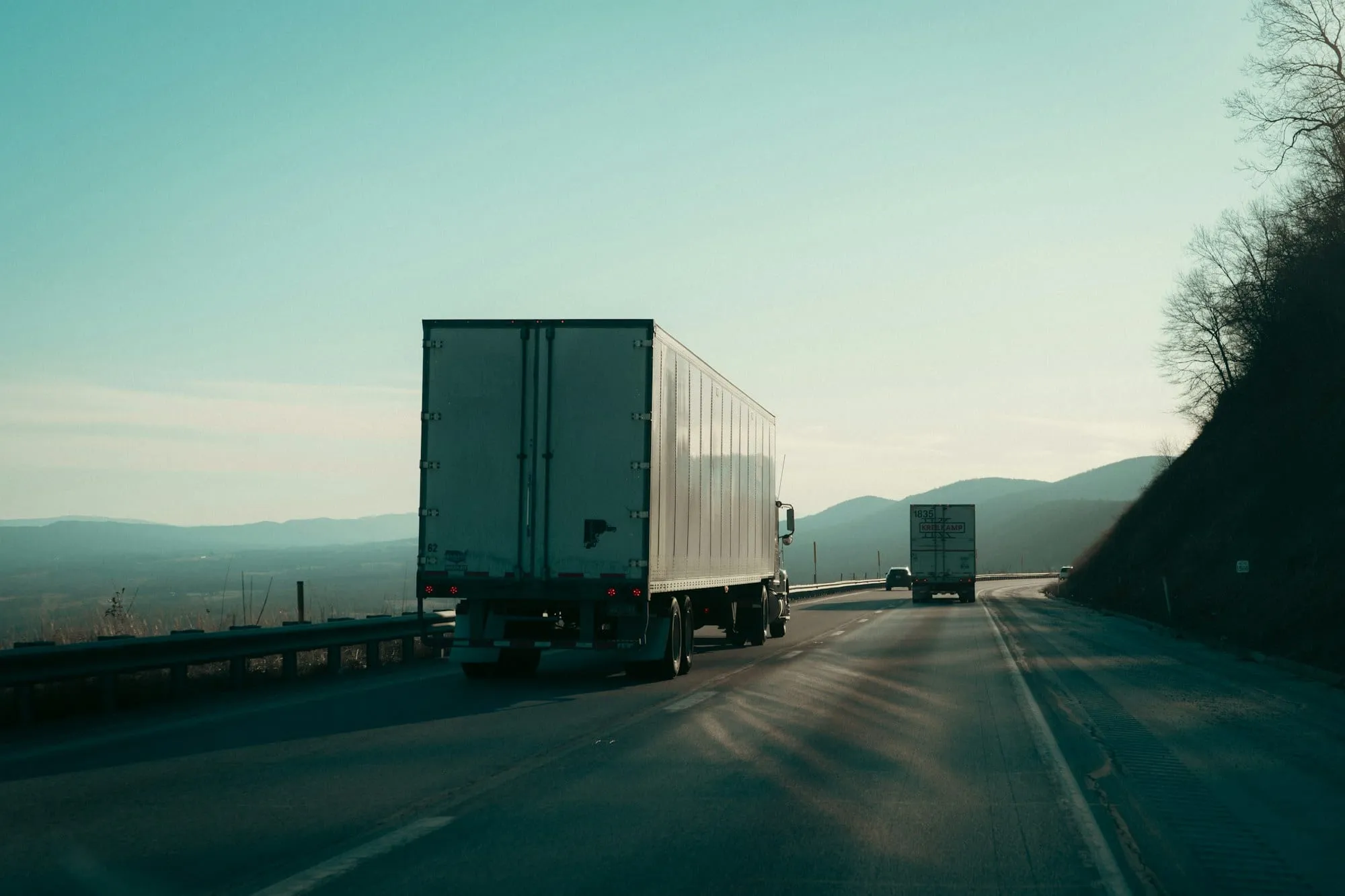 Two semi trucks on an open highway