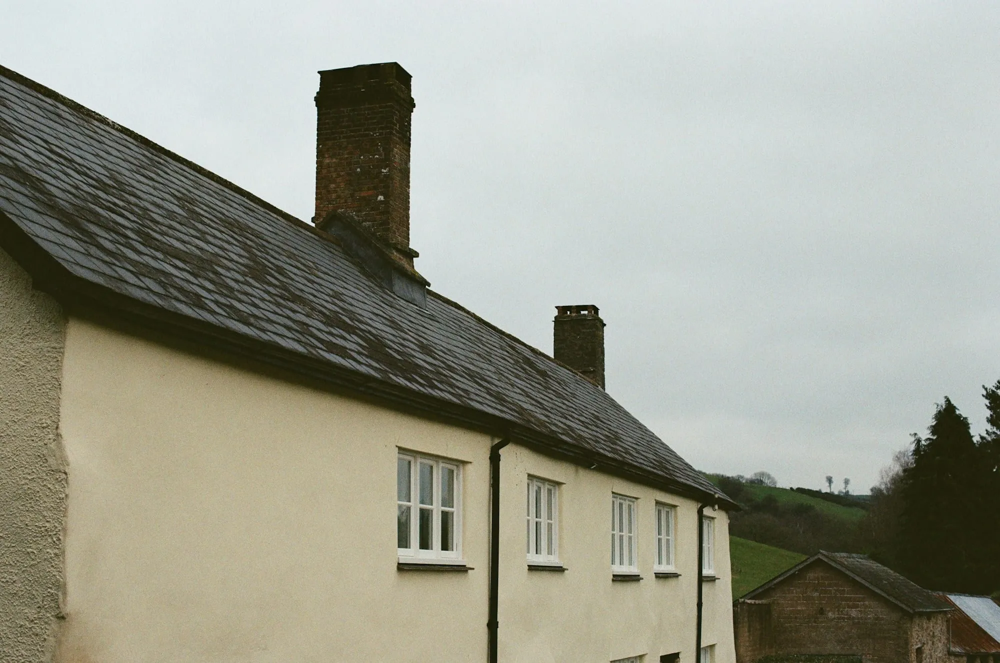 Cottage with a slate roof and brick chimneys